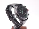 Three-quarter angled view of the black Gucci 126.2 watch, highlighting the textured dial and black leather strap.