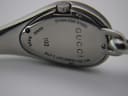 Close-up of the Gucci 103 watch case back, engraved with 'GUCCI', '103', 'STAINLESS STEEL', 'SWISS MADE', and 'WATER RESISTANT 3 ATM'.