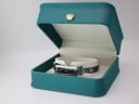 The Gucci 110 watch displayed in a green presentation box with a gold crown emblem (studio prop).
