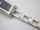 Close-up of the stainless steel bracelet links near the watch case, showing an embossed 'gucci' logo on one link.
