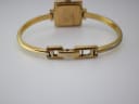 Rear view of the Gucci 1900 L watch with the hidden deployment clasp open, showing the gold-tone bracelet and case back.