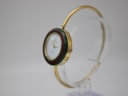 Angled side view of the Gucci change bezel watch with a green and red striped bezel, highlighting the elegant bangle design and crown.