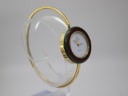 Another angled view of the Gucci change bezel watch on a stand, showcasing the gold-tone bangle and colourful bezel.