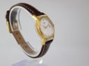 Another angled view of the Tissot watch on a stand, showing the curved lugs and white stitching on the brown leather strap.