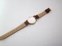 Rear view of the Tissot watch, showing the case back and the "Genuine Leather" inscription on the underside of the strap.