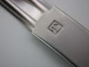 Macro shot of the stainless steel bracelet clasp, featuring the engraved Tissot 'T' logo.