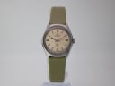 Front view of Certina Club 2000 watch with champagne dial and green leather strap, on a clear stand.