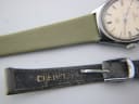 Close-up of the original worn black leather strap, with 'CERTINA' embossed on its underside.