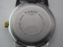 Close-up of the Tissot PR 50 watch case back, detailing engravings including "TISSOT 1853", "SAPPHIRE CRYSTAL", "STAINLESS STEEL", "WATERRESISTANT 50M", and serial number "J336/436K QKS-JA 11993".