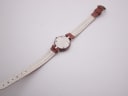 Full length view of the Tissot RockWatch with its case back and underside of the strap visible, laid flat.