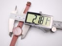 Top-down view of Tissot RockWatch R140 case being measured by a digital caliper, displaying a diameter of 21.81mm.