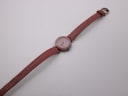 Full length view of the Tissot RockWatch with pink leather strap laid flat on a white background.