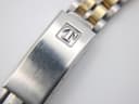 Close-up of the brushed stainless steel fold-over clasp with the embossed Tissot 'T' logo.