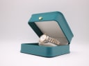 Tissot PR 100 watch displayed in a green leatherette studio presentation box.