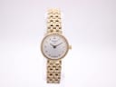Front view of Tissot T058009 A ladies quartz watch with gold tone case and bracelet, silver sunburst dial, and applied baton indices on a white background.