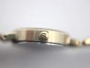 Close-up side view of the Tissot watch crown, featuring a subtle Tissot "T" logo.