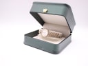 The Tissot watch displayed in a green presentation box with a gold crown emblem on a white background.