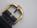 Close-up of the gold tone pin buckle with engraved "RW" logo