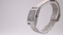 Side view of the GUCCI 7700L watch on a clear display stand, highlighting the rectangular case and mesh bracelet.