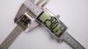 Digital caliper measuring the case width of the GUCCI 7700L watch at 24.01 mm, confirming the watch size.