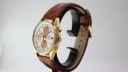 Side view of the Seiko 7T32-7R3A watch on a display stand, showing the crown, pushers, and profile of the gold-tone case.