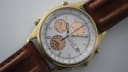 Close-up, angled view of the Seiko 7T32-7R3A watch showing the white dial with salmon sub-dials and brown leather strap.