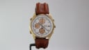 Front view of the Seiko 7T32-7R3A watch on a display stand, highlighting the white dial, gold case, and brown leather strap.