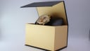 The Seiko 7T32-7R3A watch presented inside a plain gold and black display box, angled upwards.