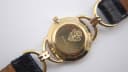 Close-up of the gold-tone case back with Gucci crest engraving, model number 6000.2.L and serial number.