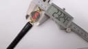 Digital caliper measuring the case diameter of the Gucci watch at 23.24mm.
