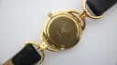 Rear view of the Gucci 6000L watch case back, displaying the engraved Gucci logo and '6000L' model number on the gold-toned surface.