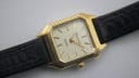 Close-up of the Bulova's cream dial, applied gold baton indices, and the textured black leather strap.