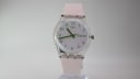Front view of Swatch Day-Date with white iridescent dial, green numerals, and light pink strap.