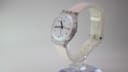 Angled view of the Swatch Day-Date, showing the transparent case and light pink rubber strap.