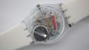 View of the transparent case back of the Swatch watch, revealing the quartz movement and battery.