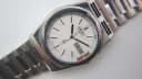 Close-up of the white dial showing the day-date complication and 'alarm' text at 12 o'clock.