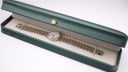 Tissot two-tone watch displayed in a green presentation box.