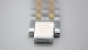 Close-up of the two-tone bracelet clasp, signed with a 'T' logo.