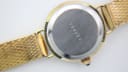 Close-up of the watch's stainless steel case back, showing the serial number '388054' and some surface scratches.