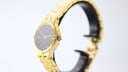Side view of the gold tone Tissot Stylist watch, highlighting the crown and case profile.