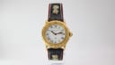 Front view of Michel Jordi 1891 Jubilee gold tone watch with white dial and embroidered black leather strap.