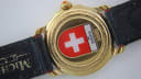 Close-up of the Michel Jordi case back with a red Swiss flag emblem, "Water Resistant", "Michel Jordi", and "1891 Suisse" engravings.