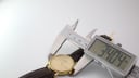 Digital caliper measuring the case diameter of the Tissot watch at 34.04mm.