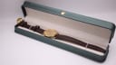 The Tissot watch resting inside a generic green presentation box with a white interior.