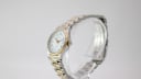 Profile side view of the Certina watch and bracelet on a clear stand.