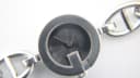 Close-up of the G-Gucci watch's black dial with concentric circle texture, showing silver baton hands and the Gucci logo.