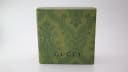 Top view of the closed original Gucci green paisley patterned box with the Gucci logo.
