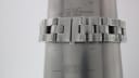 The integrated steel bracelet of the Gucci 2305L watch on a wrist sizing cone, indicating a wrist size of approximately 16.5cm.