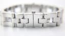 Close-up of the integrated steel bracelet, showing the hidden butterfly clasp with "GUCCI" engraving.