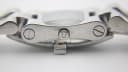 Close-up side view of the watch case, showing the signed crown and screw details on the lugs.